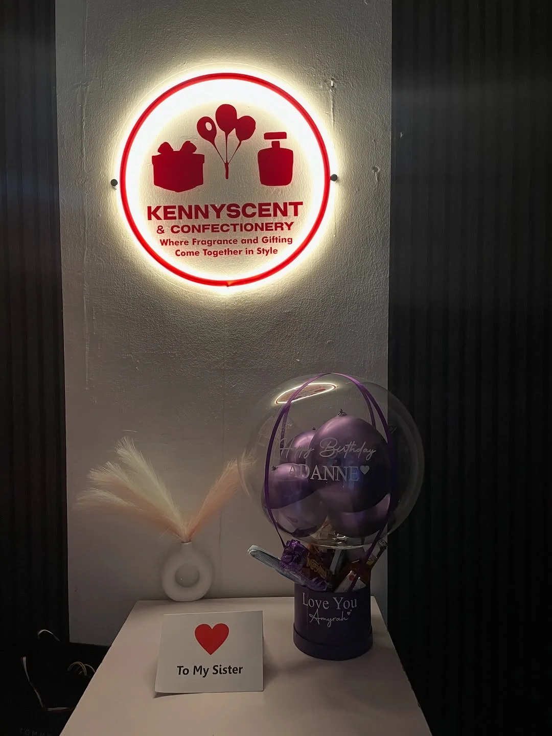 Kenny's studio with the round Kennyscent neon sign